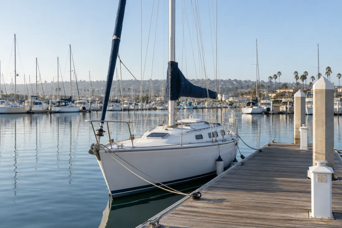 Representative neighborhood scene: A sailboat moored beside an empty marina dock