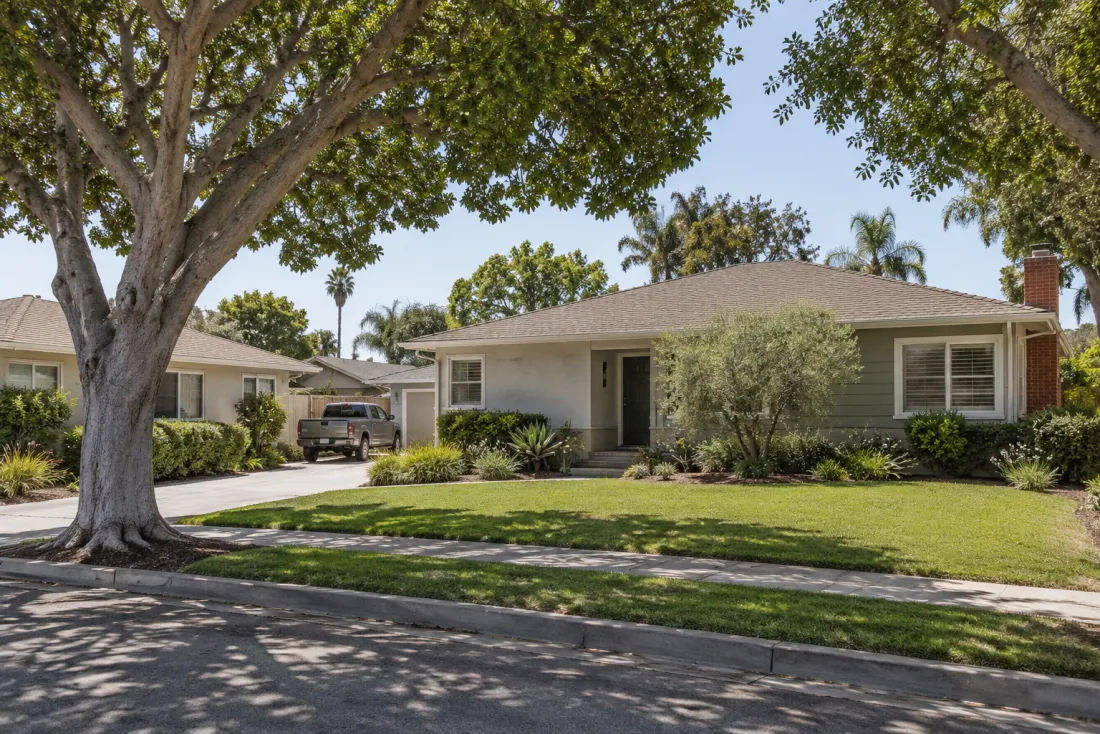 Representative neighborhood scene: Single-story ranch homes and a shaded residential driveway